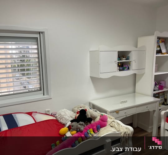 חדר ילדים עם מיטות, שולחן וצעצועים